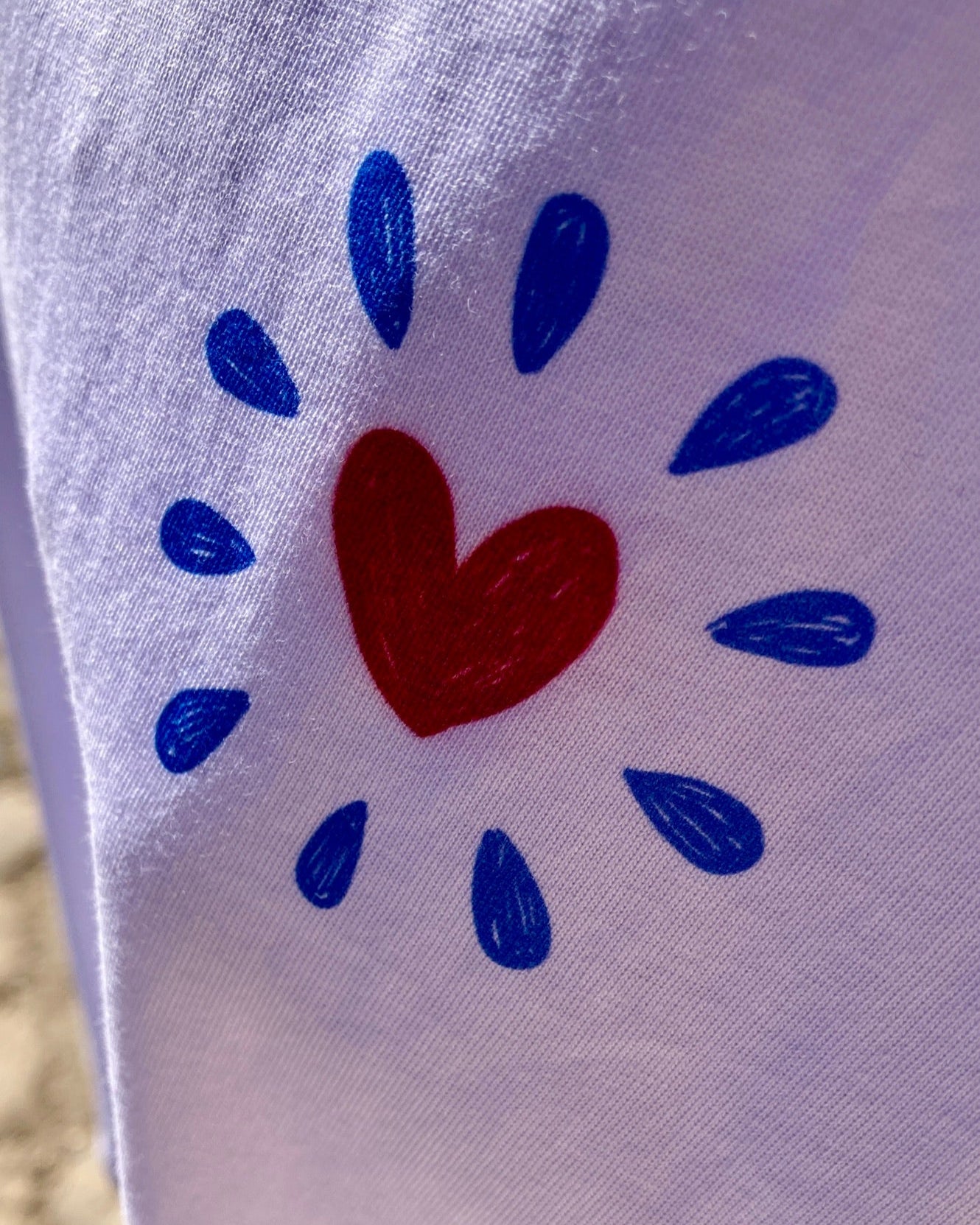 White fabric with a red heart and blue dots design.