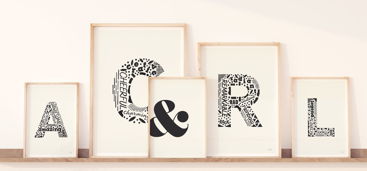 5 framed art prints with the letter "A", "C", "R", "L", and "&" in black and white. Each letter is composed with detailed text and patterns.